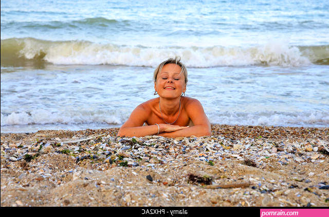Portrait of a beautiful naked woman lying in the sand Stock Photo