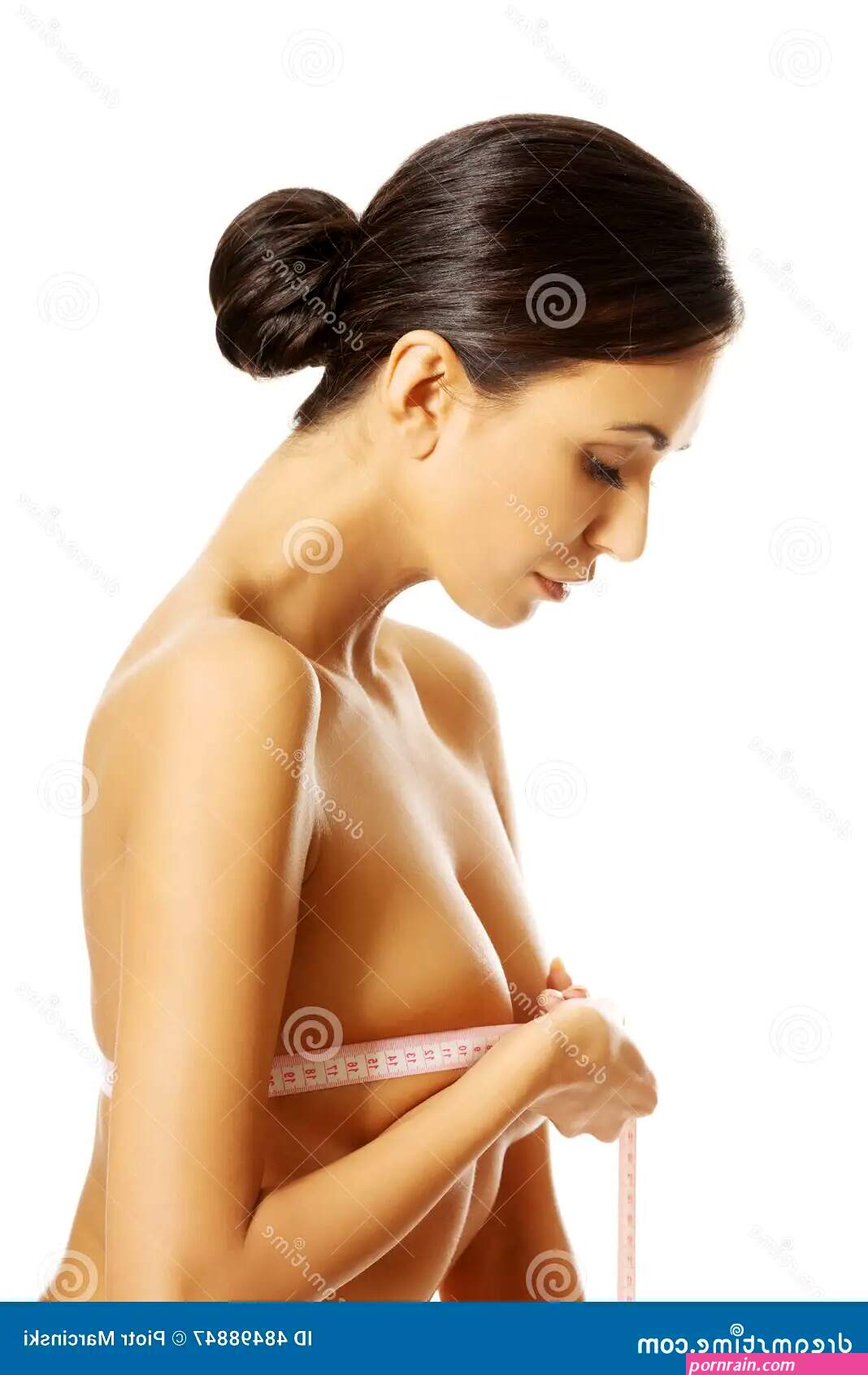 Side View of a Nude Woman Measuring Her Breast Stock Image
