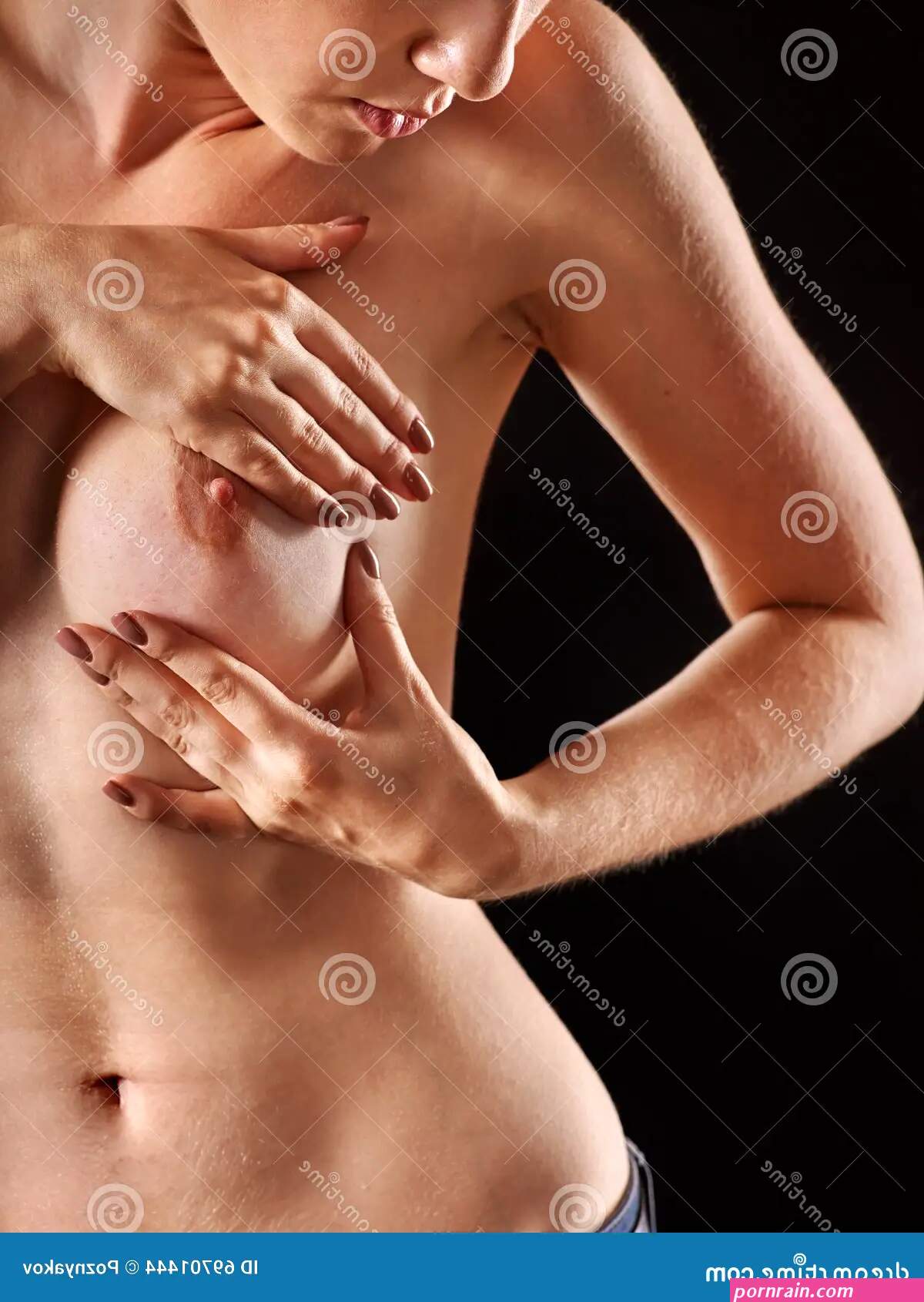 Nude Girl Sees Her Bare Breast. Stock Photo