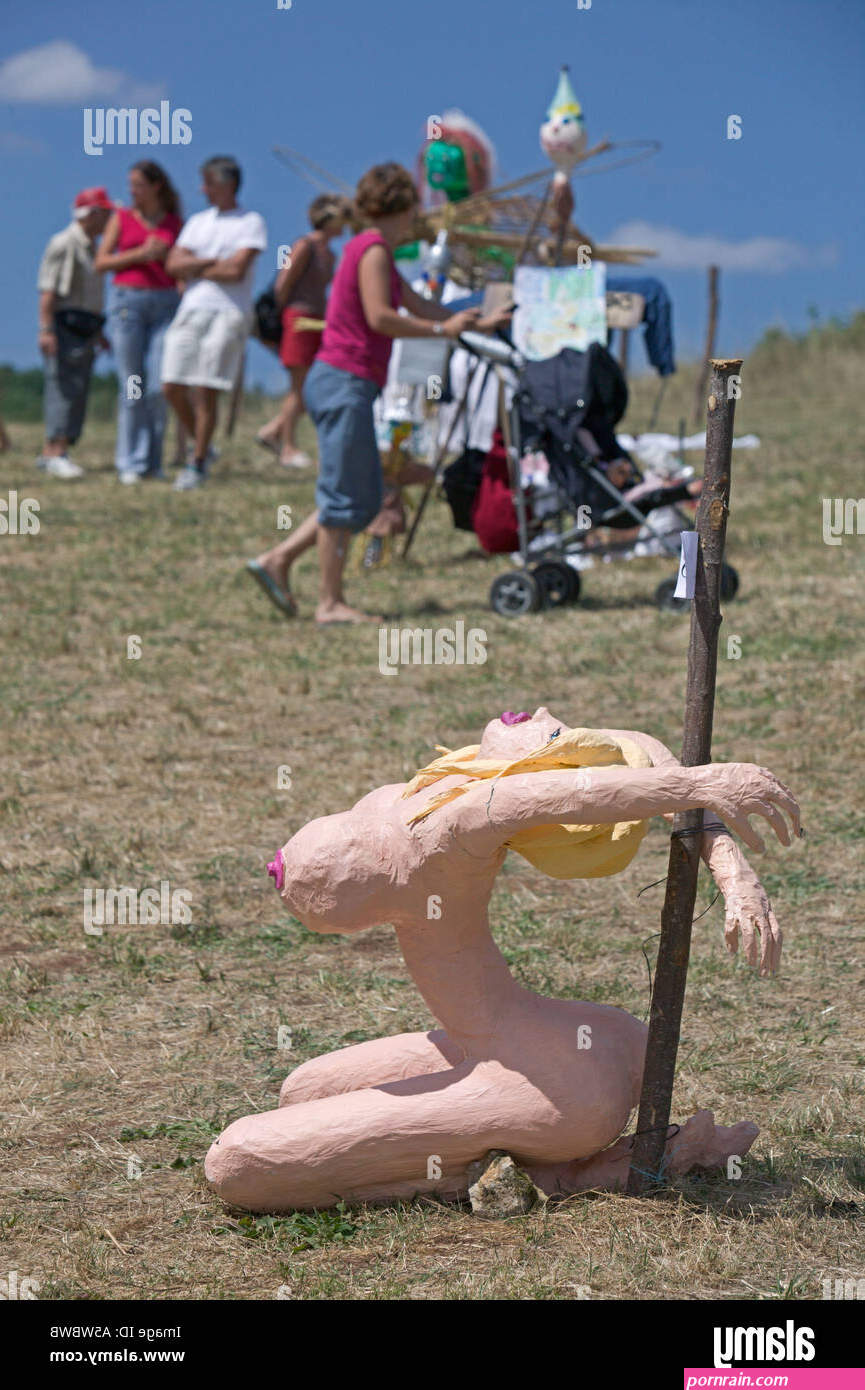 Exhibit of naked woman tied to stake at a family scarecrow festival Stock Photo