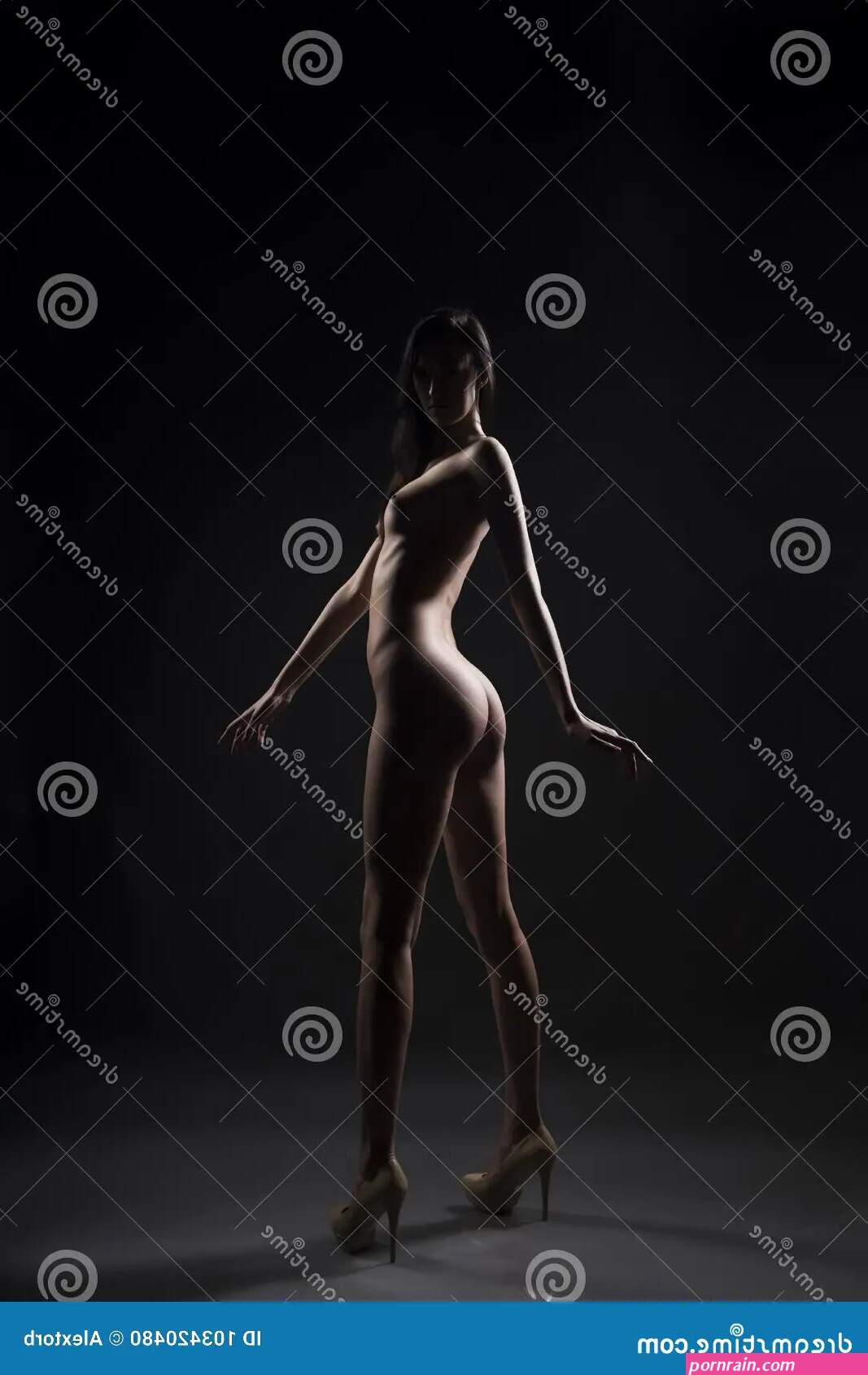 Silhouette of the Thin Slim Naked Girl on a Dark Background Stock Photo