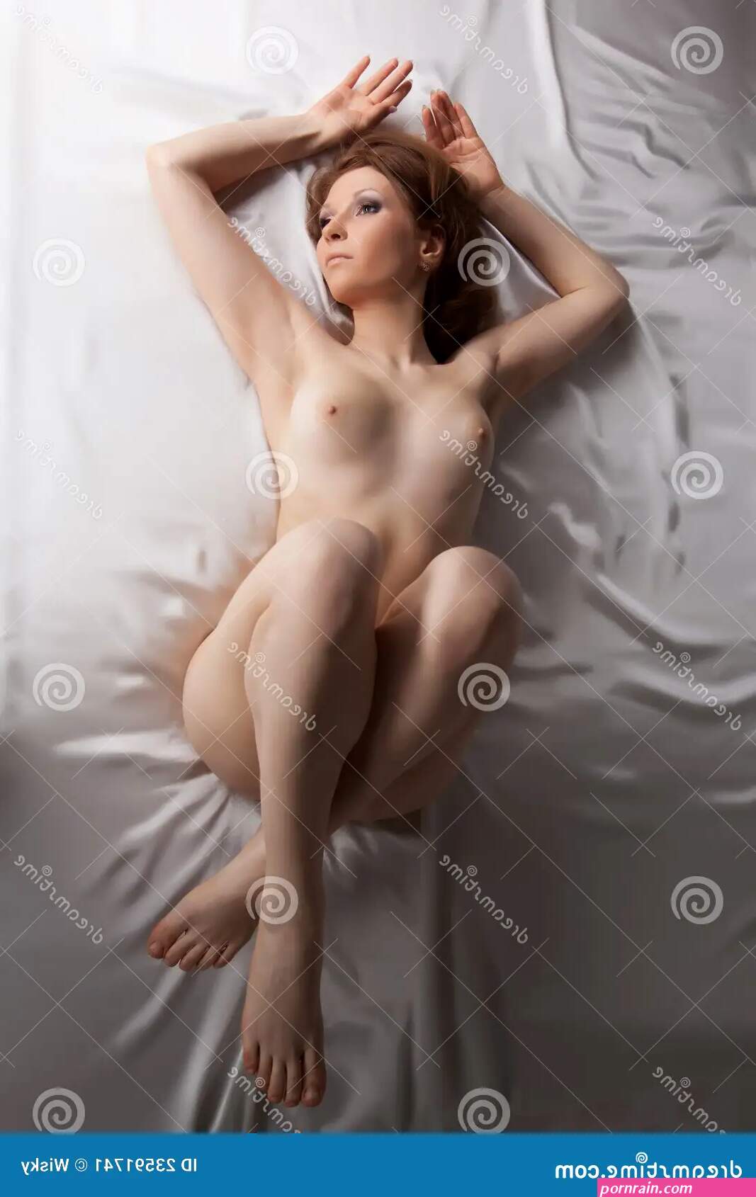 La Mujer Joven Desnuda Pone En La Cama De Seda Blanca Imagen de archivo