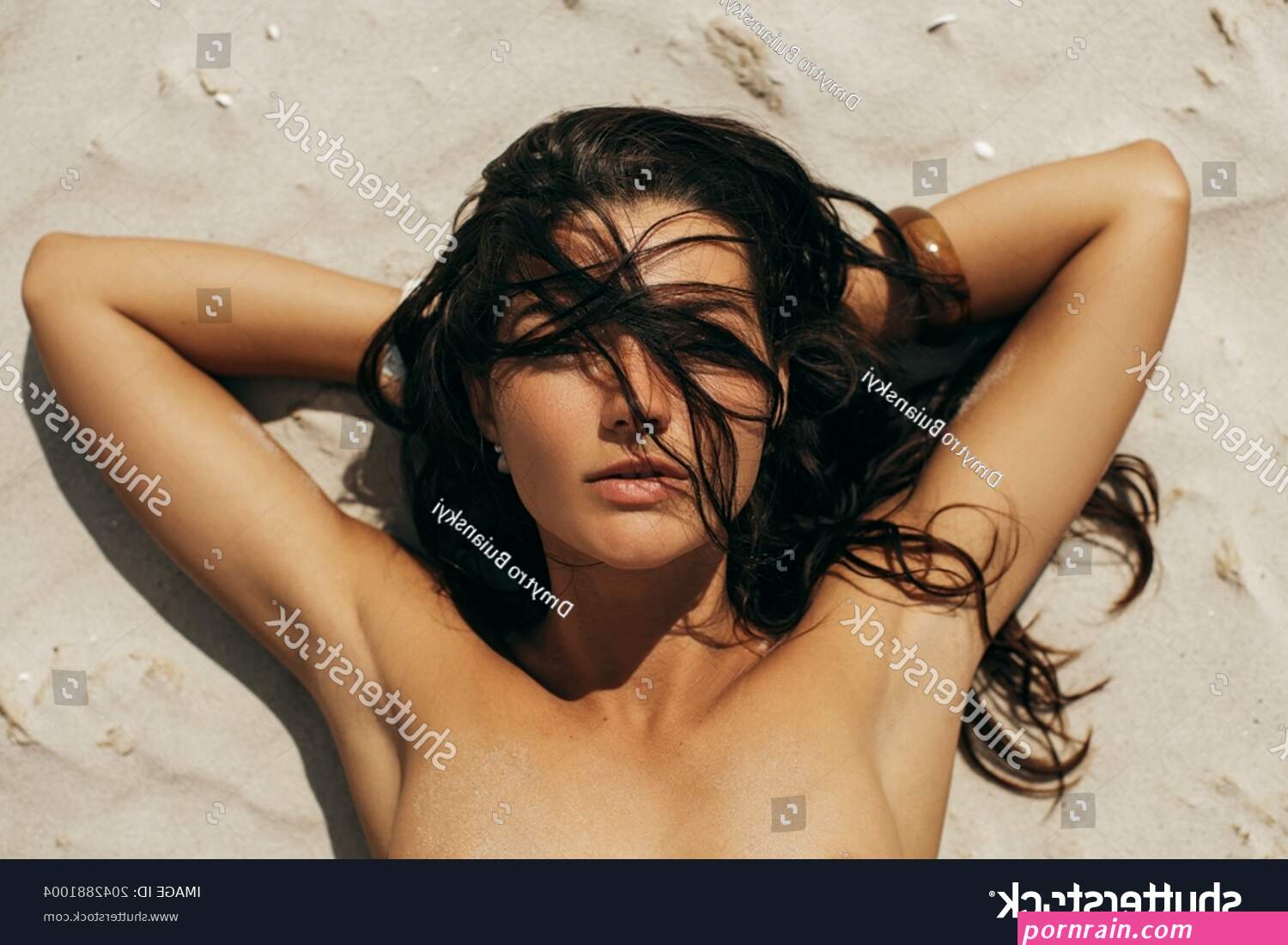 Nude Woman Sunbathing On Nudist Beach Foto stock 2042881004
