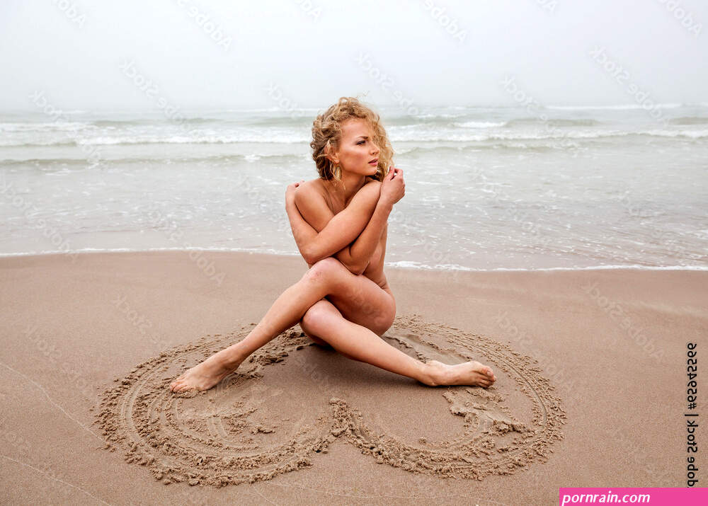 Foto Stock Nude woman on sea beach in foggy day