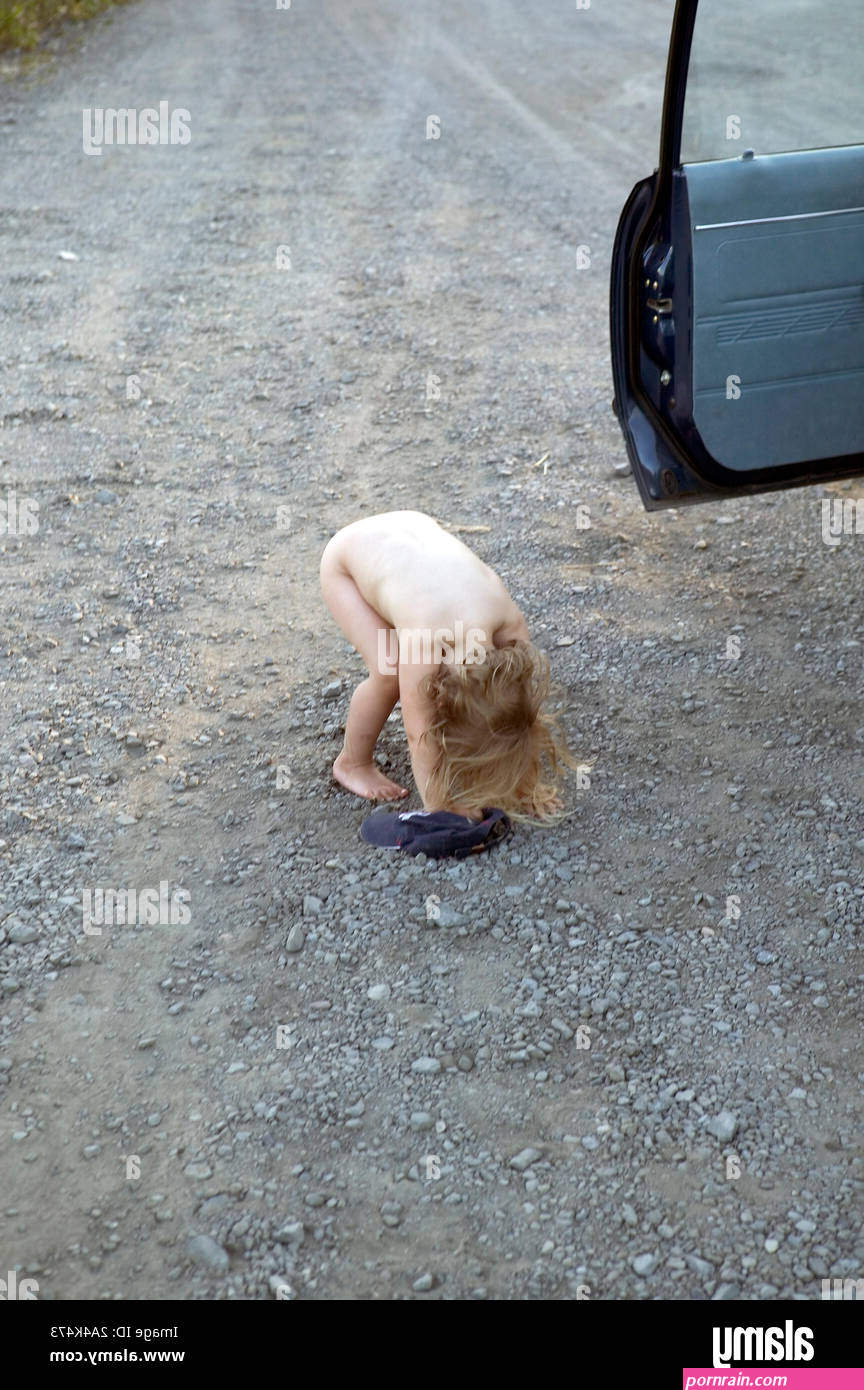 Girl peeing in the road Stock Photo