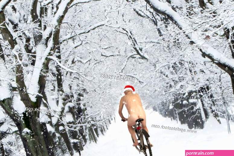 Naked male with Christmas hat on bike riding through avenue in winter snow Stock Photo Picture And Rights Managed Image. Pic. MEV-13132683