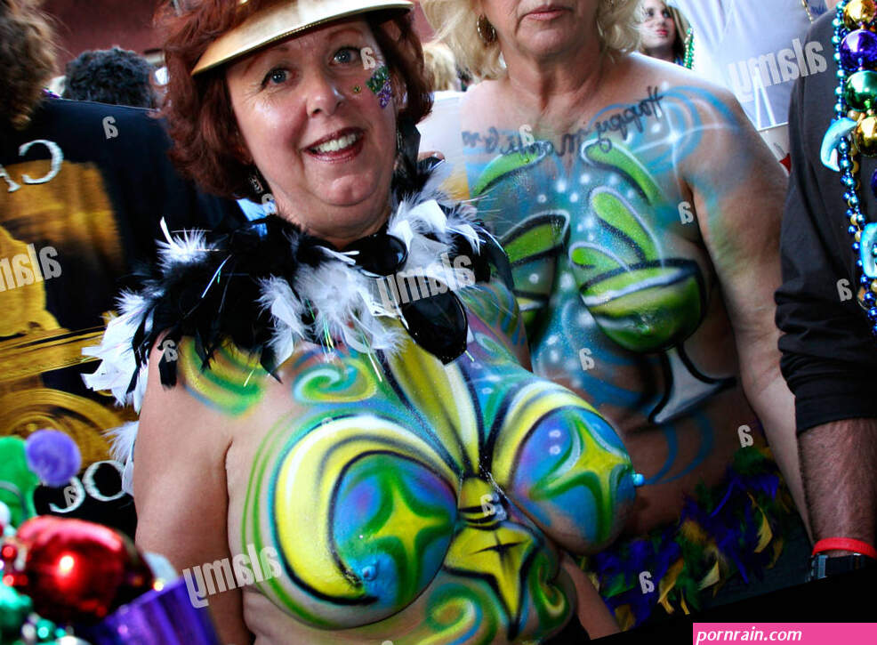 Older women topless and with painted breasts on bourbon street in new orleans Stock Photo