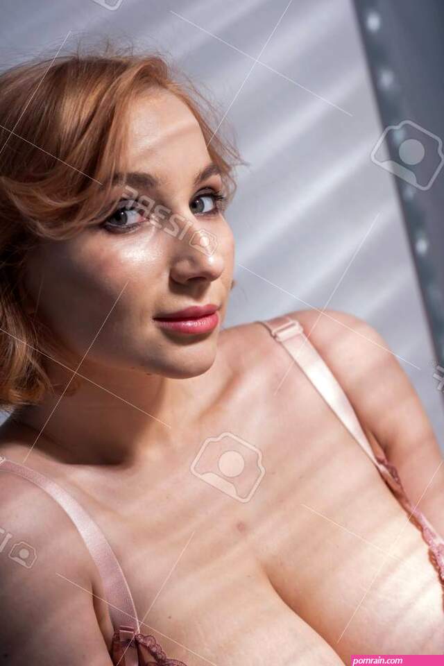 A Beautiful Young Woman With Very Large Natural Breasts Is Standing By The Window With Shutters. A Girl In Pink Lace Shows A Beautiful Figure Next To A White Screen. Huge Female