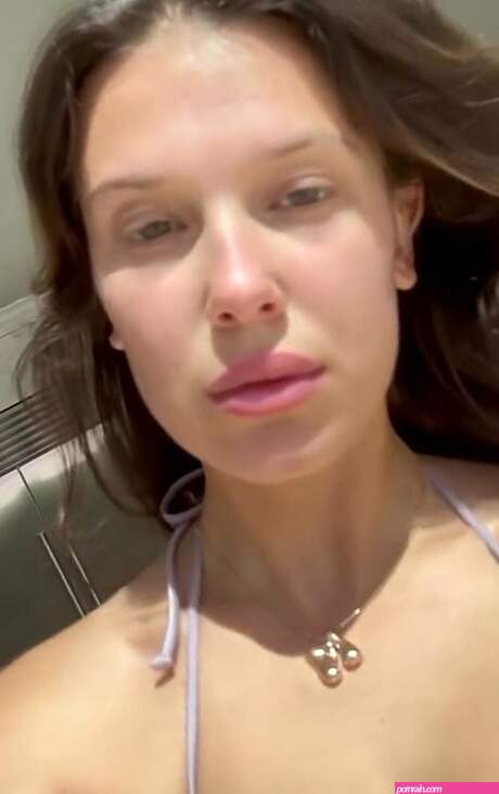 Millie Bobby Brown shows off her sensational figure in a purple bikini and green shorts as she films herself getting pool ready at her lavish home