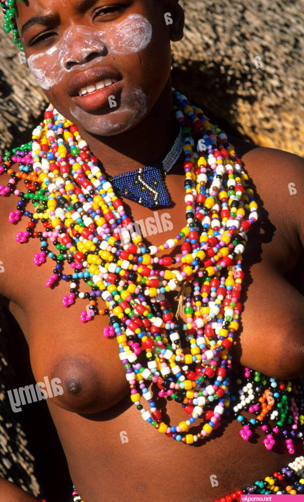 Zulu woman in beads and native costume topless near Kruger National Park in South Africa near hut Stock Photo