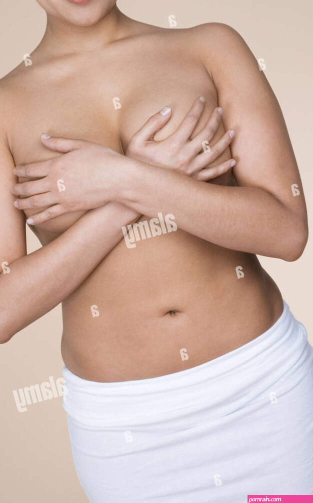 Topless woman covering her breasts Stock Photo